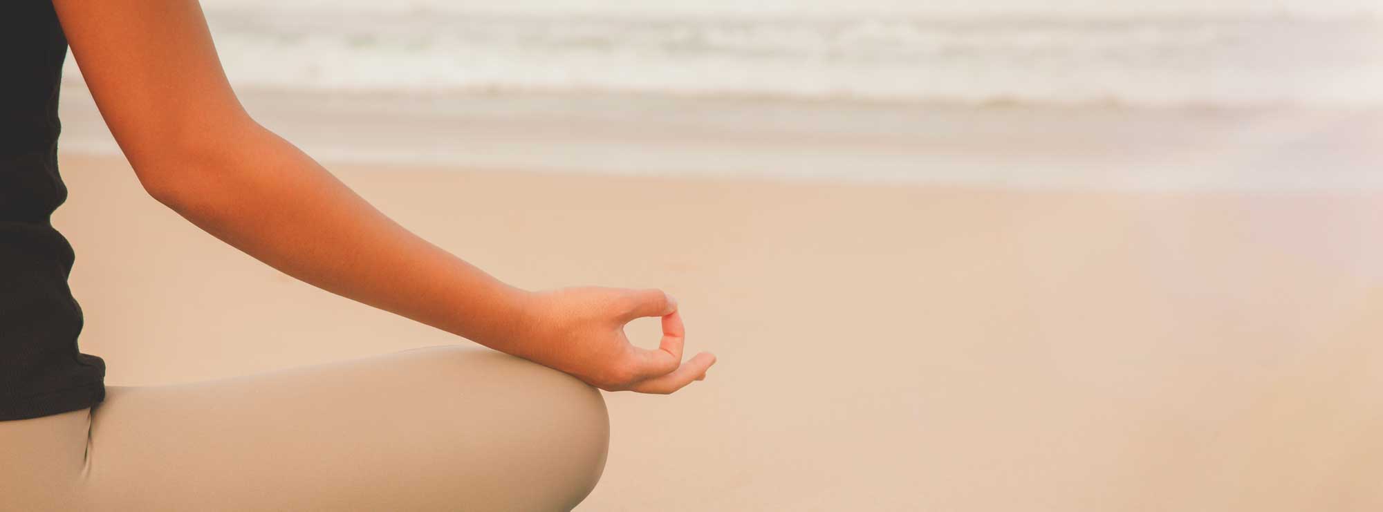 closeup-woman-meditating-practicing-yoga-beach